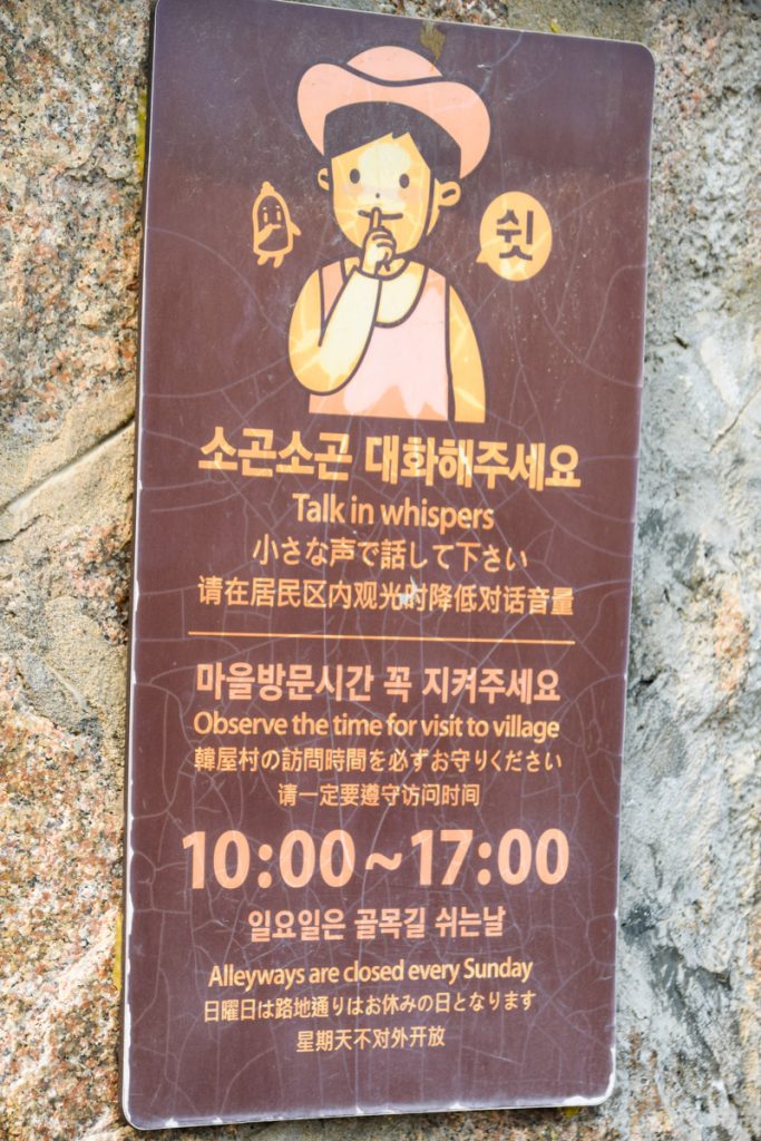 Sign with the hours for Bukchon Hanok Village